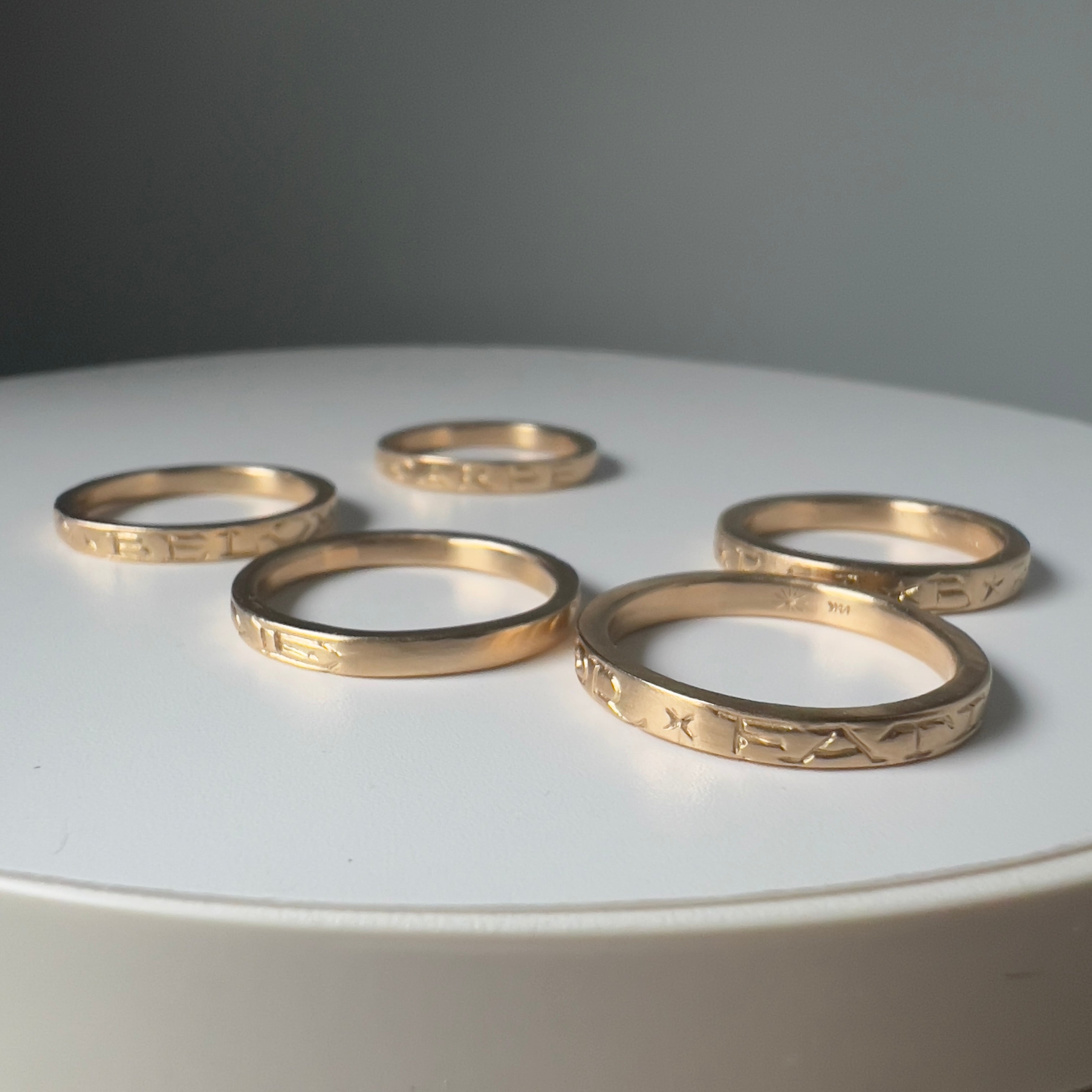 Close-up detail of hand-carved AS ABOVE SO BELOW alchemical phrase on 14k gold ring, showing intricate craftsmanship of luxury talisman jewelry